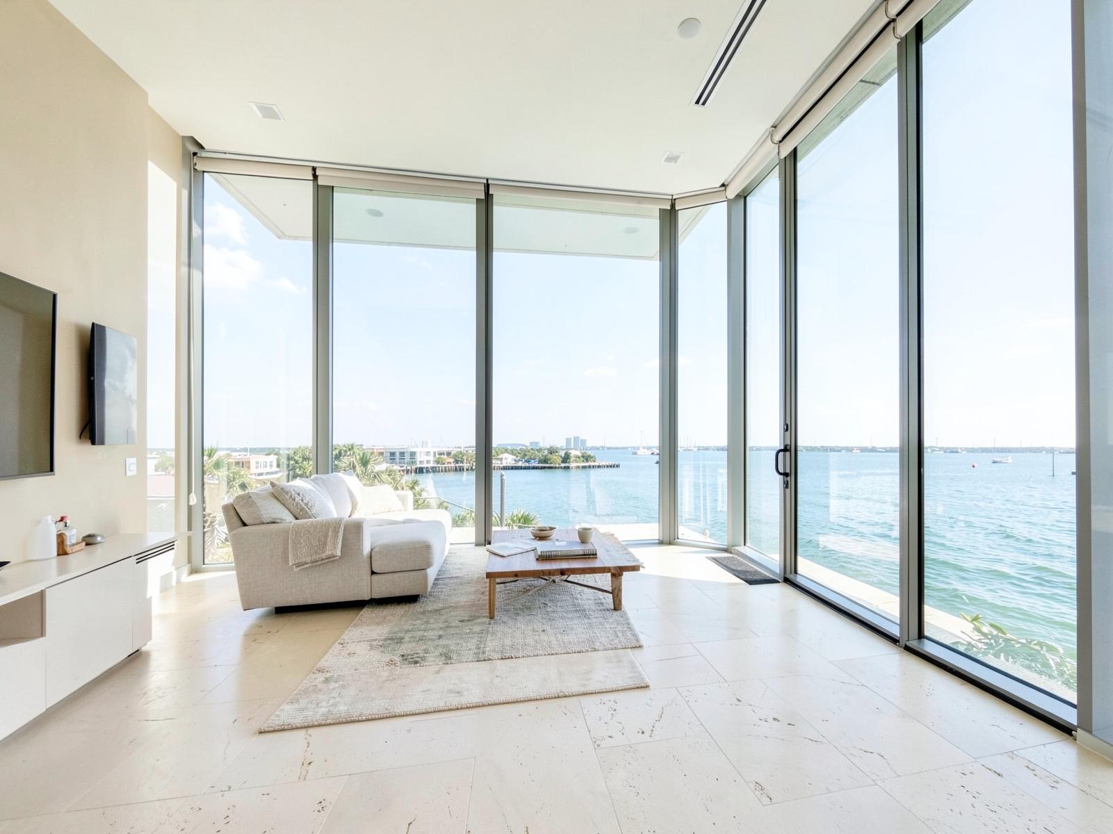 Bright coastal living room with floor-to-ceiling glass over the water